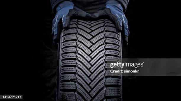 man's hands pushing tyre - band stockfoto's en -beelden