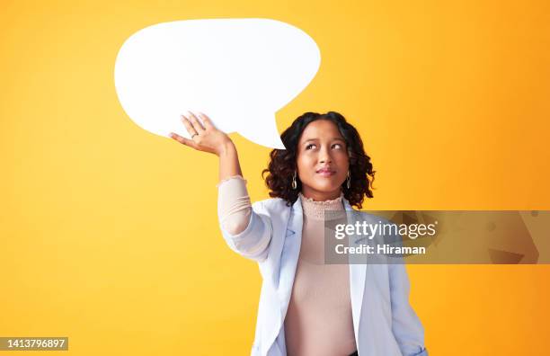 worried, pensive and thinking woman pondering a question or difficult decision. african american female brainstorming ideas, holding an empty speech bubble against yellow copyspace background. - speech bubble people stock pictures, royalty-free photos & images