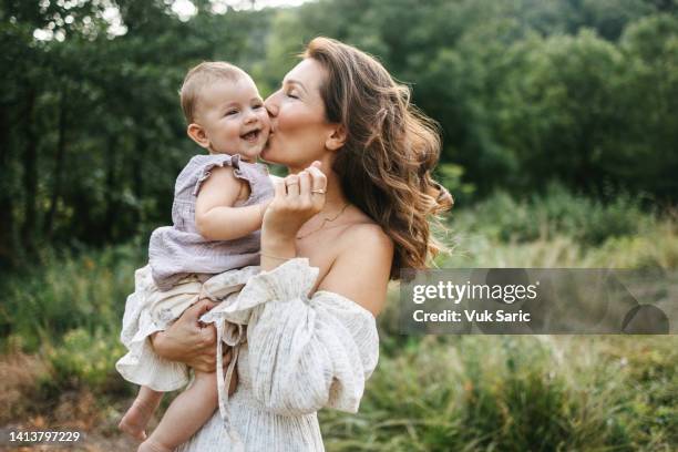 mutter küsst ihr baby - weißes kleid stock-fotos und bilder