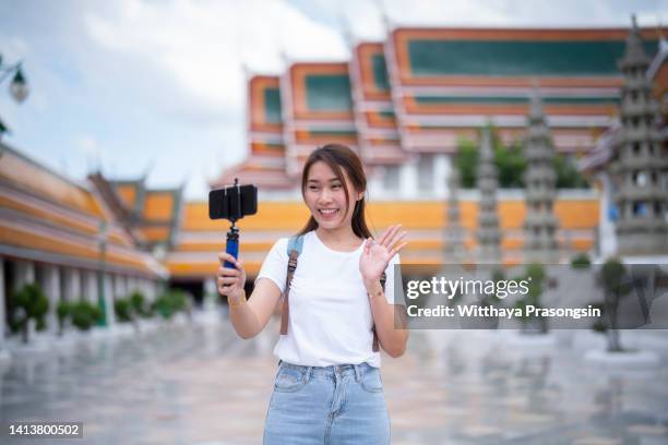 young female tourist holding a gimbal with smartphone and recording videos. travel blogger and vlogger concept - one woman only videos stock pictures, royalty-free photos & images