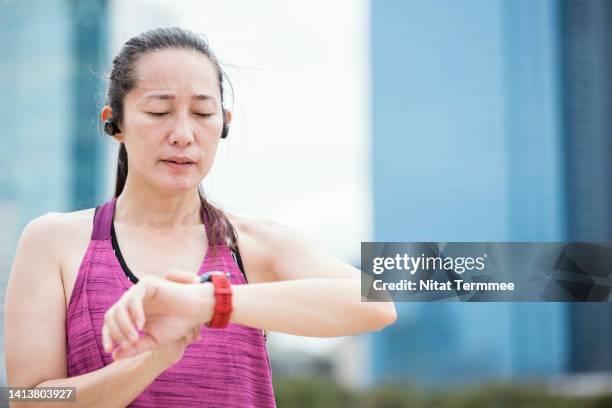 monitor your heart rate on your smartwatch. asian sportswomen used a fitness app on a smartwatch to take heart rate measurements during workouts to track heart health. - asian female bodybuilder stock pictures, royalty-free photos & images