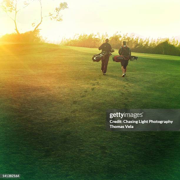 two golfers walking on golf course - american golf stock pictures, royalty-free photos & images