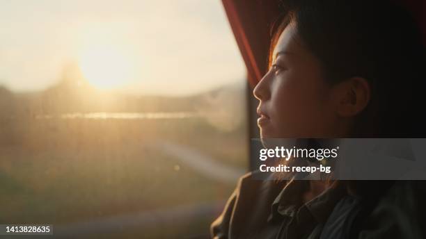 young female tourist sitting at window seat in bus and looking at view through the window - coach bus 個照片及圖片檔