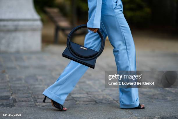 Angela Gonzalez wears a pale blue cropped / oversized blazer jacket, matching pale blue suit pants, a black shiny leather Rond handbag from...