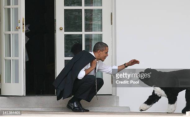 President Barack Obama greets his dog Bo outside the Oval Office of the White House March 15, 2012 in Washington, DC. Obama spoke today at Prince...