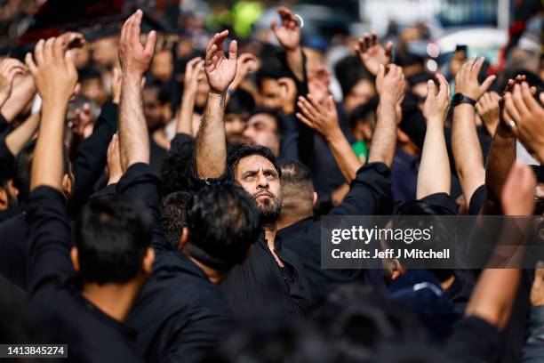 Muslim men chant during the Ashura festival procession through Glasgow on August 09, 2022 in Glasgow, Scotland. Ashura is a day of atonement for...