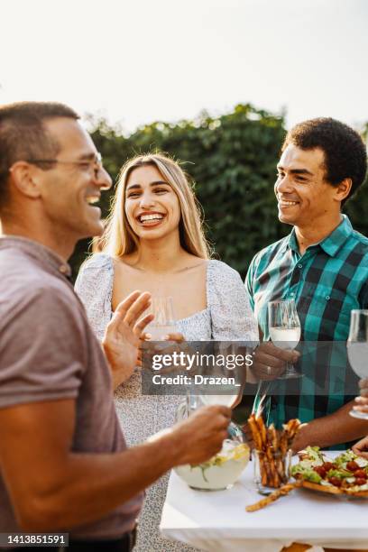 multiracial couple drinking wine on garden party - open air dining stock pictures, royalty-free photos & images
