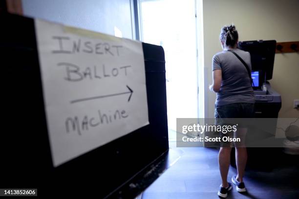 Voter casts her ballot at the the library on August 09, 2022 in Oconomowoc, Wisconsin. Wisconsin is holding its primary election today.