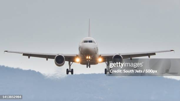 low angle view of airplane against sky - airplane front view stock pictures, royalty-free photos & images