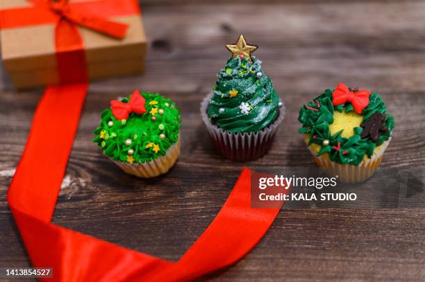 delicious homemade cupcakes with christmas design on wooden textured table - cupcake box stock pictures, royalty-free photos & images