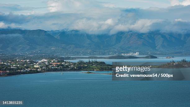 scenic view of sea by city against sky,new caledonia - franse overzeese gebieden stockfoto's en -beelden