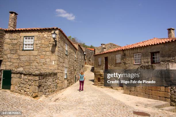 woman walking along sortelha, sabugal, guarda district, portugal. - mountain village stockfoto's en -beelden