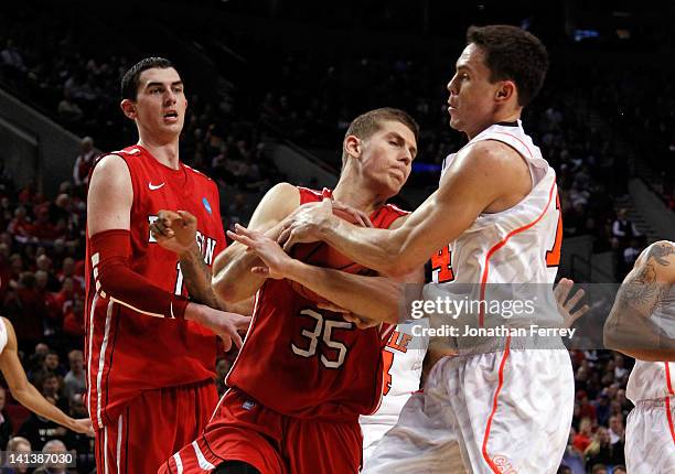 Chris Czerapowicz of the Davidson Wildcats with the ball as he is covered by Kyle Kuric of the Louisville Cardinals in the second half in the second...