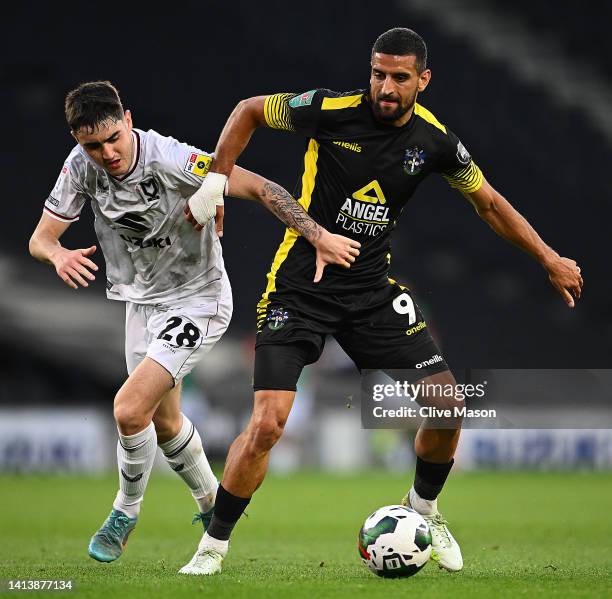 Omar Bugiel of Sutton United is challenged by Dawson Devoy of MK Dons during the Carabao Cup First Round match between Milton Keynes Dons and Sutton...