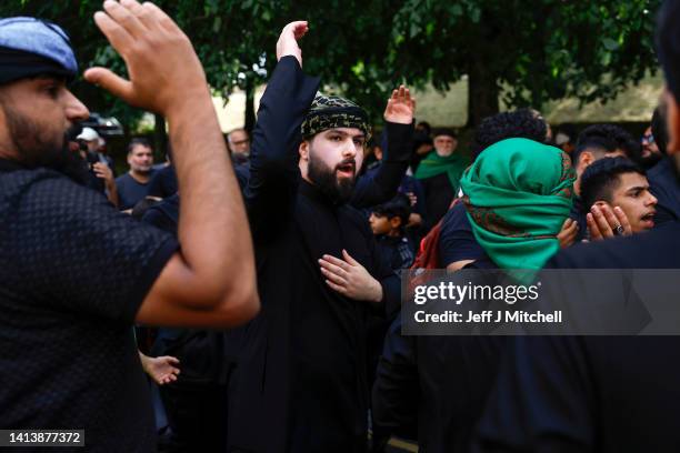 Muslim men chant during the Ashura festival procession through Glasgow on August 09, 2022 in Glasgow, Scotland. Ashura is a day of atonement for...