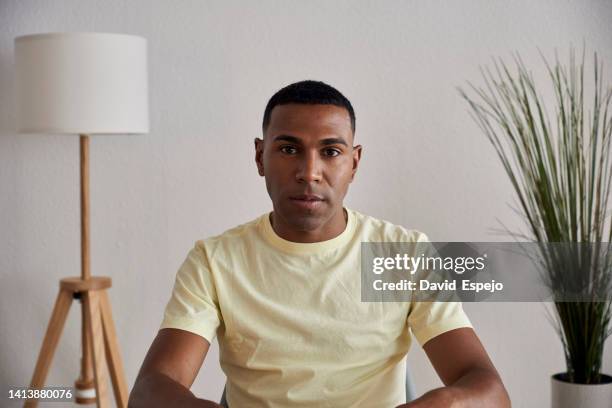 man looking at camera while having video call at home. - serious interview stock pictures, royalty-free photos & images