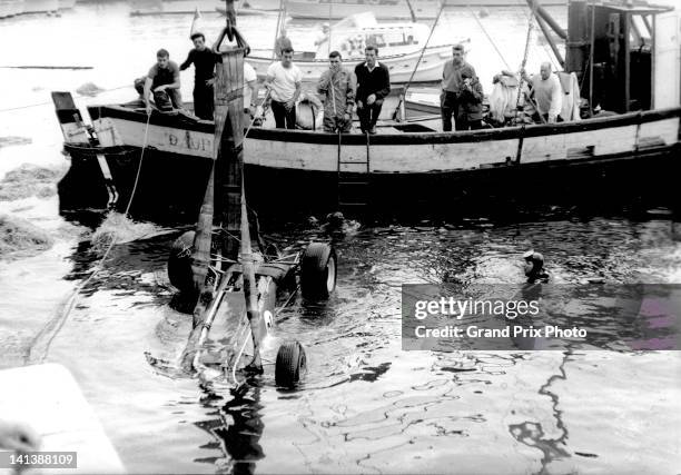 The DW Racing Enterprises Lotus 33 Climax V8 of Paul Hawkins of Australia is recovered from the harbour after crashing on lap 79 during the Monaco...