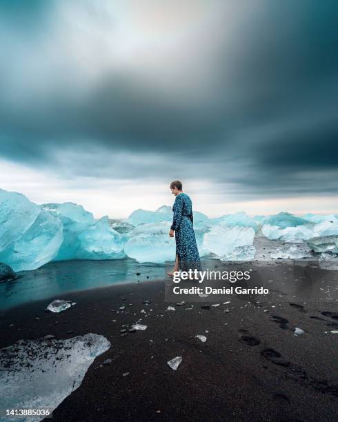 girl with short hair and barefoot and with a dress walking on diamond beach, iceland, landscapes photography - ice princess stock pictures, royalty-free photos & images