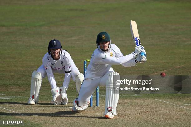 Rassie van der Dussen of South Africa plays a shot as Sam Billings of England Lions looks on during the tour match between England Lions and South...