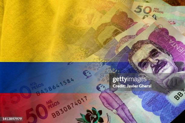 colombian pesos cash bills and colombia flag - colombian peso stock pictures, royalty-free photos & images