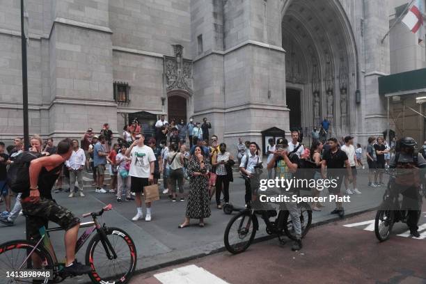 People watch as smoke engulfs Fifth Avenue, blocks away from Trump Tower, as a fire breaks out in a building under construction on August 09, 2022 in...
