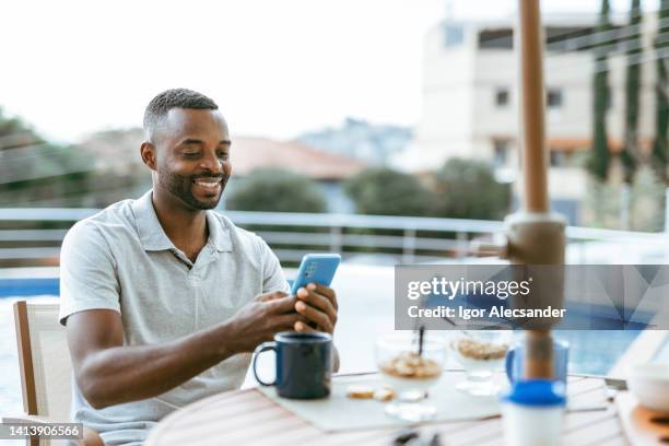 man using smartphone during breakfast outdoors - financial freedom stock pictures, royalty-free photos & images