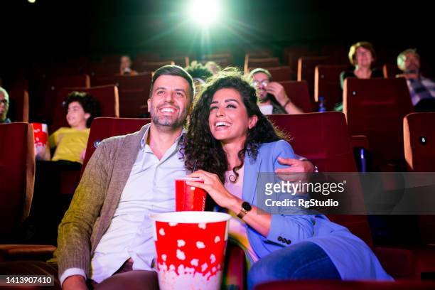 couple watching a comedy film at the cinema and enjoying together - film premiere stock pictures, royalty-free photos & images