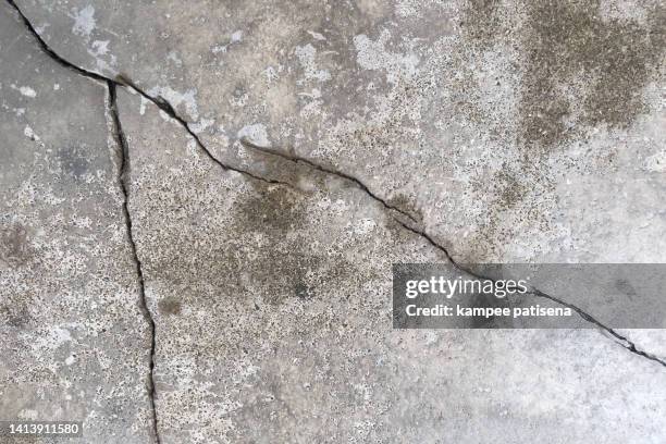 cracks in the floor concrete - zerrissen stock-fotos und bilder