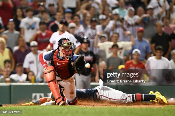 Ronald Acuna Jr. #13 of the Atlanta Braves slides safely into home behind Kevin Plawecki of the Boston Red Sox during the eighth inning at Fenway...