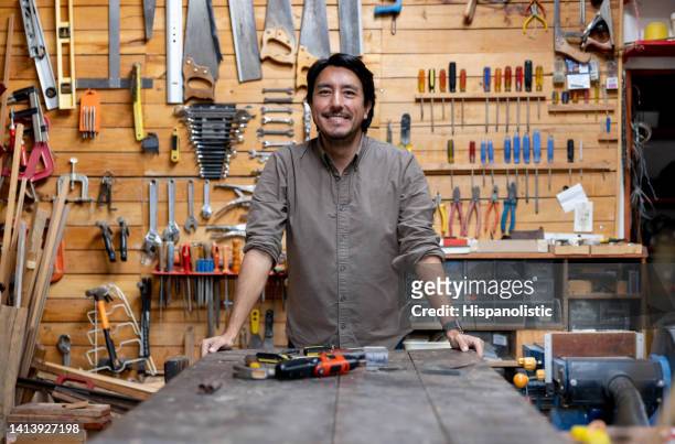 happy man working on a project at his home workshop - man cave 個照片及圖片檔