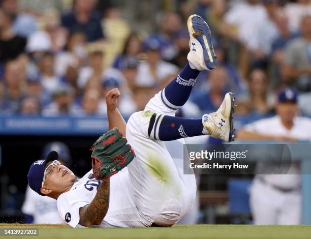 Julio Urias of the Los Angeles Dodgers reacts after his throw to first base on an infield RBI single from Gilberto Celestino of the Minnesota Twins,...