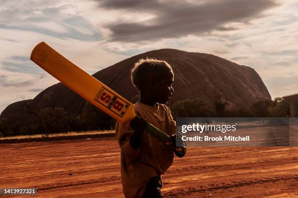 Child plays cricket during the ICC Men's T20 World Cup Trophy Tour at Mutitjulu on August 09, 2022 in Uluru, Australia. Mutitjulu is an Aboriginal...