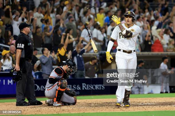Manny Machado of the San Diego Padres reacts after hitting a three-run homerun as Austin Wynns of the San Francisco Giants looks on during the ninth...