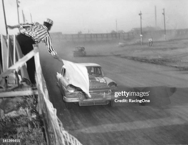 April 28, 1957: Race leader Paul Goldsmith takes the white flag during a NASCAR Cup race at the Greensboro Fairgrounds. Goldsmith went on to victory...
