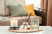 Scented candles and aroma incense sticks on table in living room. Aromatherapy, home fragrance. Concept of home relaxation and anti stress.