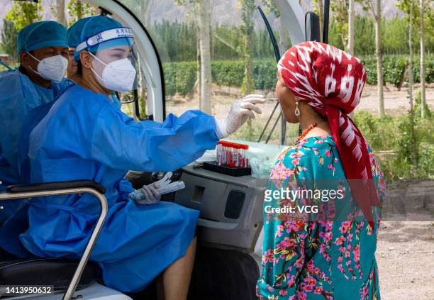 Nurse takes swab sample from a worker for COVID-19 nucleic acid test at a vineyard on August 9, 2022 in Korla, Bayingolin Mongol Autonomous...