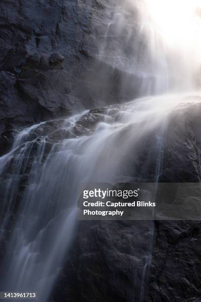 closeup of water falling on rocks - river rock stock pictures, royalty-free photos & images