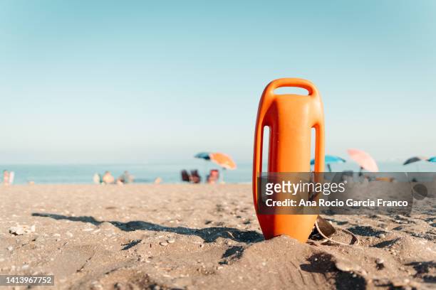 lifeguard buoy in the sand at the beach - lifeguard fotografías e imágenes de stock
