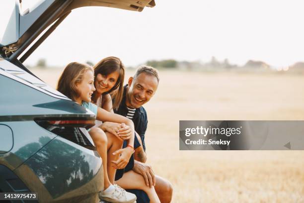 family in the car - couple on the beach with car stockfoto's en -beelden