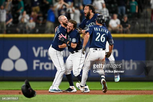 Mitch Haniger, Adam Frazier, and J.P. Crawford celebrate with Luis Torrens of the Seattle Mariners after his game winning walk-off single against the...