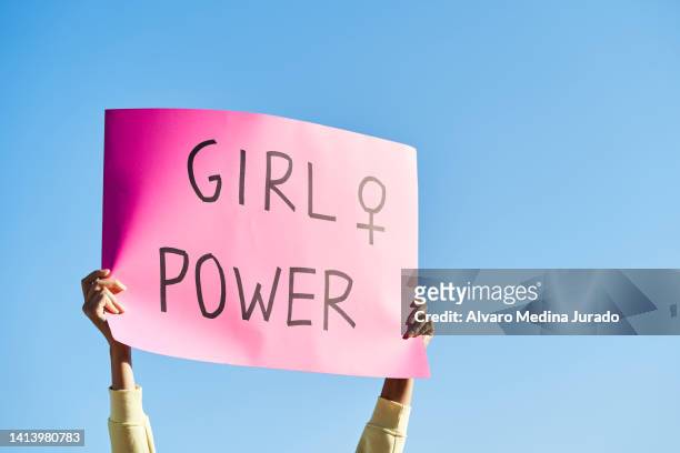 unrecognizable woman's hands holding a protest banner with the message girl power, with the blue sky in the background. - feminism stock pictures, royalty-free photos & images