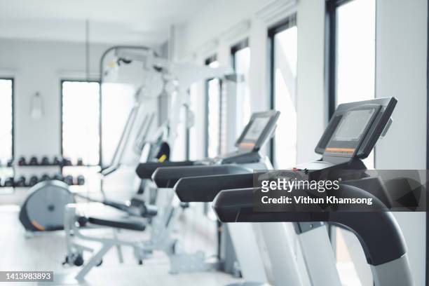 row of treadmills for running exercises in modern fitness center - exercise equipment 個照片及圖片檔