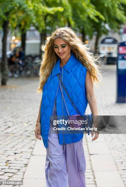 Emili Sindlev is seen wearing blue puffer vest, Chanel bag in purple, wide leg pants, sandals outside A. Roege Hove during Copenhagen Fashion Week...