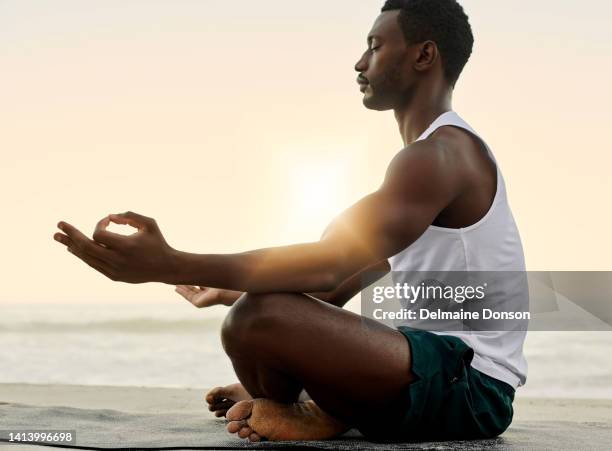 spiritual, calm and relaxed man doing meditation or lotus yoga pose exercise with sunset beach background and copy space. young athletic, fit and healthy yogi guy practicing inner peace by the ocean - zen man stock pictures, royalty-free photos & images