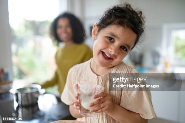 little multiracial girl sitting in kitchen table and eating breakfast. high angle view. - caught in the act fotografías e imágenes de stock