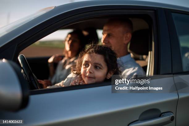 multiracial family traveling for vacation by car. - girls driving a car stock-fotos und bilder