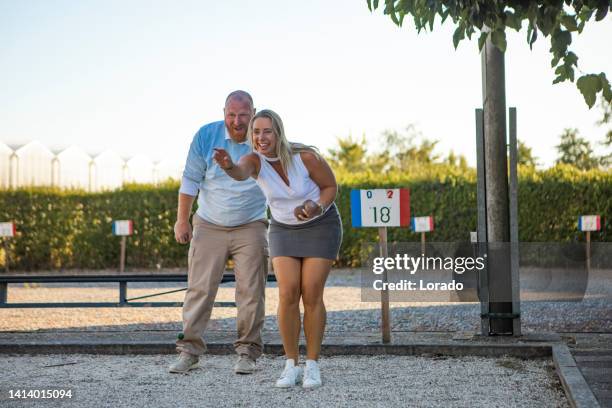beautiful active couple playing boules in the summer - boule stock pictures, royalty-free photos & images