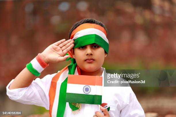 child salute to national flag on independence day - driekleurig stockfoto's en -beelden