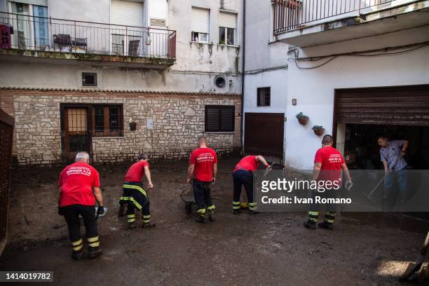 Workers of the mountain community of Partenio remove mud and debris in the streets of the town following severe flooding on August 10, 2022 in...