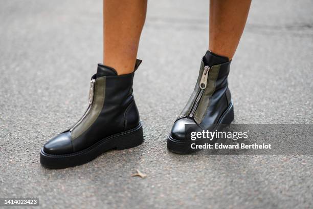 Guest wears black shiny leather zipper ankle boots, outside Gestuz, during Copenhagen Fashion Week Spring/Summer 2023, on August 09, 2022 in...